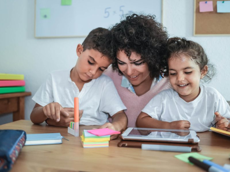 teacher-using-tablet-with-children-in-kindergarten-school-focus-on-girl-face.jpg